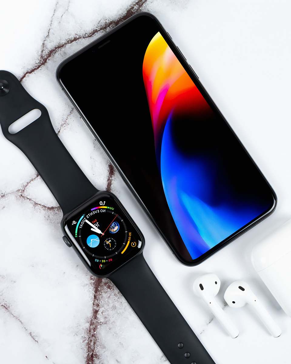 cell phone black aluminum case Apple Watch with black Sport Band and Apple AirPods on white surface mobile phone